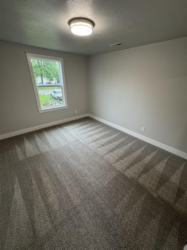 108 Jasper St, Aurora, MO 65605 - spare room featuring a textured ceiling, baseboards, and dark colored carpet