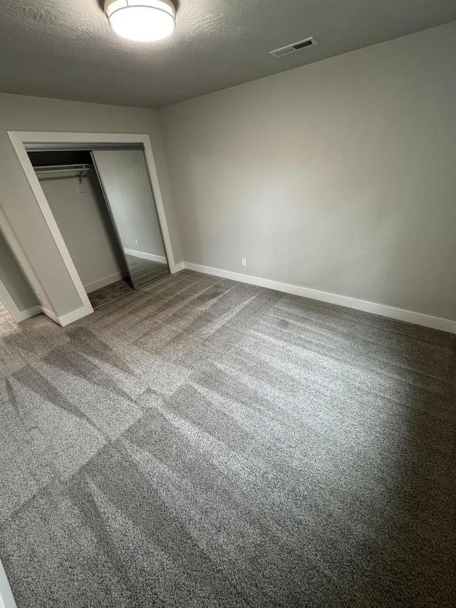 108 Jasper St, Aurora, MO 65605 - unfurnished bedroom with a closet, carpet flooring, baseboards, and a textured ceiling