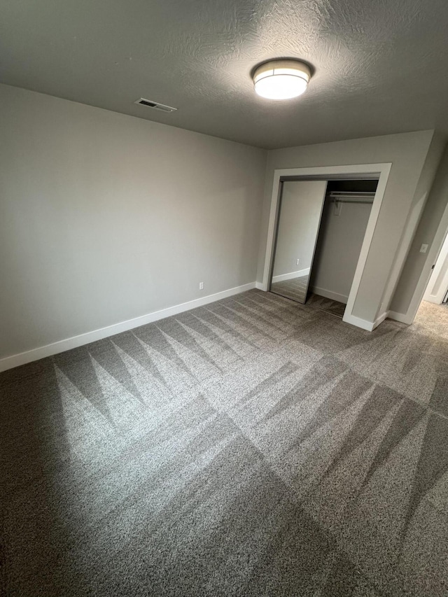 108 Jasper St, Aurora, MO 65605 - unfurnished bedroom featuring a textured ceiling, baseboards, a closet, and carpet floors