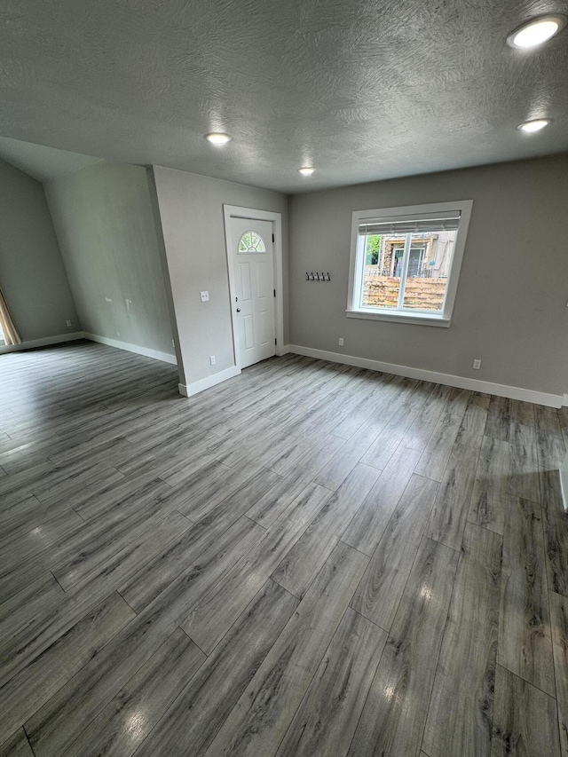 108 Jasper St, Aurora, MO 65605 - unfurnished living room with wood finished floors, baseboards, and a textured ceiling