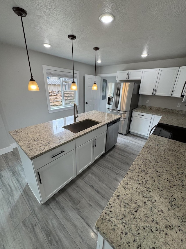 108 Jasper St, Aurora, MO 65605 - kitchen with stainless steel appliances, a sink, white cabinets, light stone countertops, and light wood-style floors