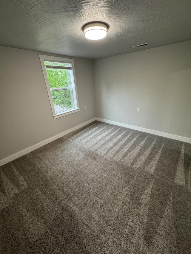 108 Jasper St, Aurora, MO 65605 - empty room with baseboards, dark carpet, and a textured ceiling