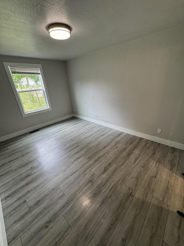 108 Jasper St, Aurora, MO 65605 - spare room featuring wood finished floors, a textured ceiling, and baseboards