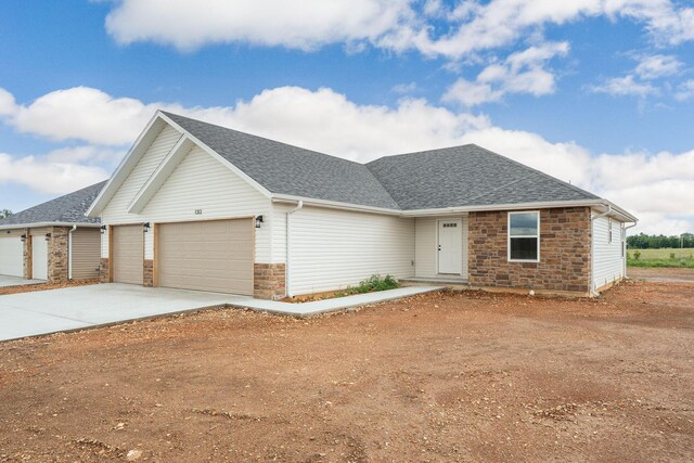 1312 N Maxine Ave, Nixa, MO 65714 - view of front facade featuring an attached garage, a shingled roof, and driveway