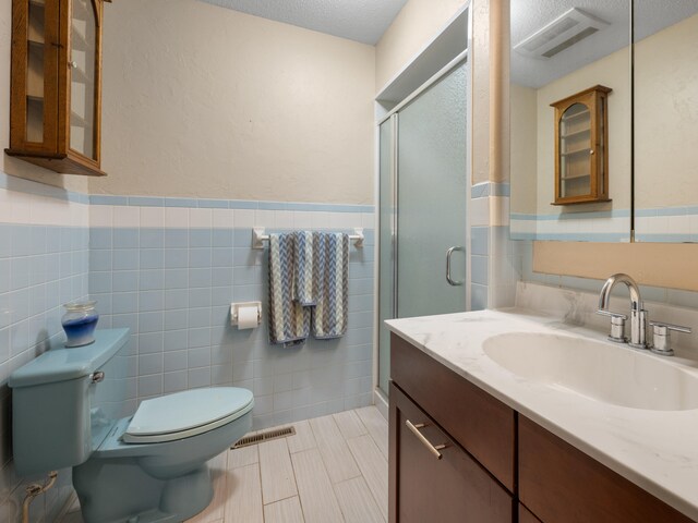 1622 Oakland Ave, Bolivar, MO 65613 - full bath with toilet, tile walls, vanity, a stall shower, and wainscoting