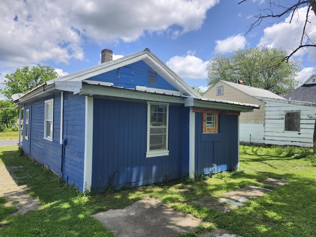 626 W N St, Mountain Grove, MO 65711 - view of side of property with a chimney, a yard, metal roof, and board and batten siding