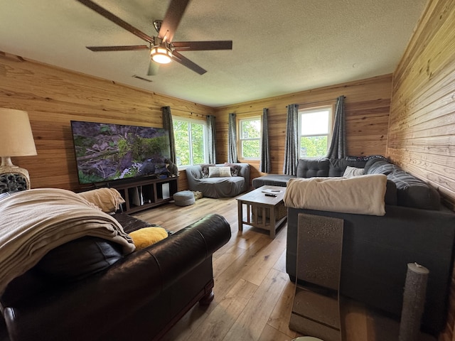 11513 Co Rd Unit 76-203, Ava, MO 65608 - living room with wood walls, a textured ceiling, healthy amount of natural light, a ceiling fan, and hardwood / wood-style flooring