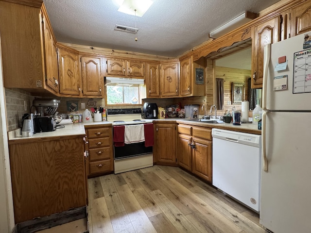 11513 Co Rd Unit 76-203, Ava, MO 65608 - kitchen with white appliances, a sink, under cabinet range hood, brown cabinets, and light wood-type flooring