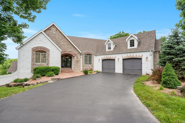 185 Appaloosa Trl, Saddlebrooke, MO 65630 - view of front facade with brick siding, an attached garage, asphalt driveway, french doors, and stone siding