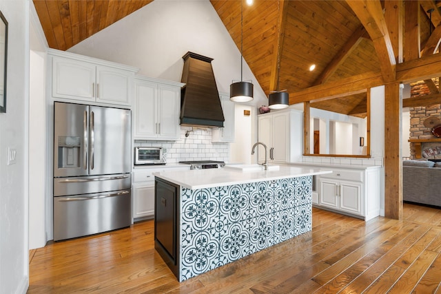 185 Appaloosa Trl, Saddlebrooke, MO 65630 - kitchen with stainless steel fridge, wooden ceiling with exposed beams, light countertops, a sink, and light wood-type flooring