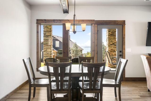 dining space featuring a chandelier, plenty of natural light, and wood finished floors