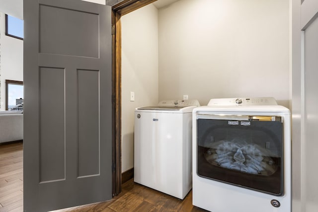 washroom featuring separate washer and dryer, dark wood-style floors, and healthy amount of natural light