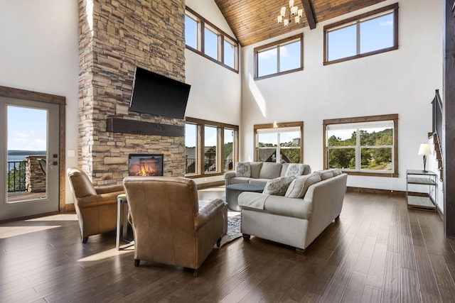 living area featuring high vaulted ceiling, a fireplace, dark wood finished floors, wood ceiling with exposed beams, and baseboards
