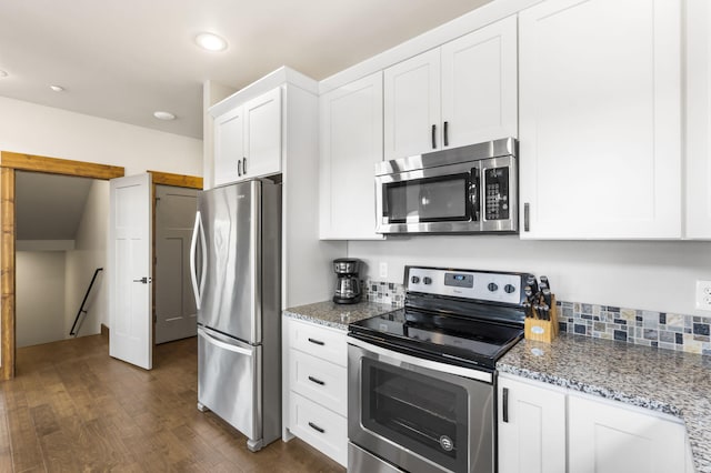 kitchen featuring appliances with stainless steel finishes, white cabinets, light stone countertops, dark wood finished floors, and recessed lighting