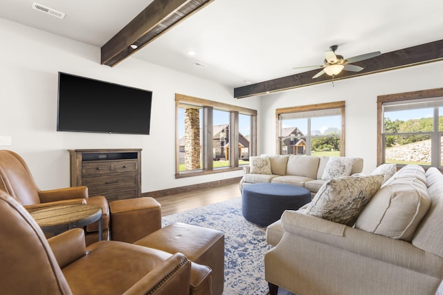 living room with beamed ceiling, wood finished floors, a ceiling fan, and baseboards