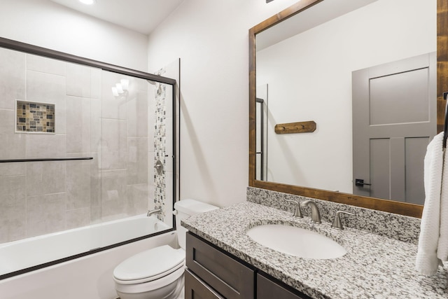 full bathroom with toilet, vanity, and bath / shower combo with glass door