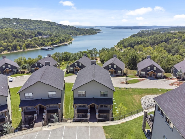 aerial view of residential area with a large body of water and a forest