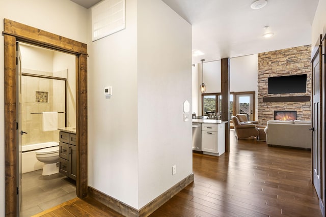 hall featuring dark wood-type flooring and baseboards