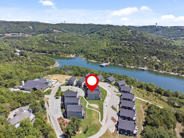 aerial overview of property's location with a forest, a nearby body of water, and nearby suburban area