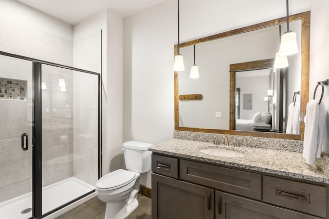 ensuite bathroom featuring vanity, toilet, a stall shower, and electric panel