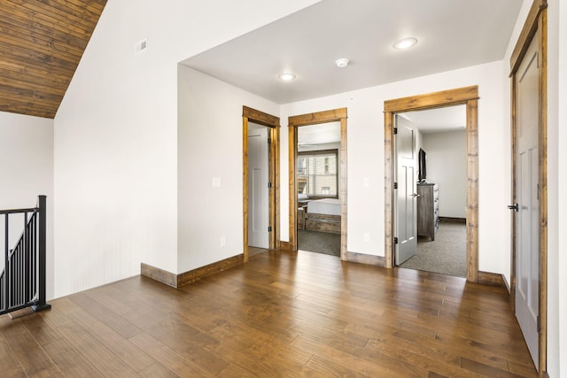 empty room featuring baseboards, dark wood-style flooring, recessed lighting, lofted ceiling, and a smoke detector