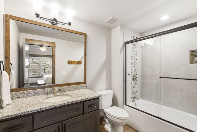 ensuite bathroom with vanity, toilet, shower / bath combination with glass door, and wood finished floors