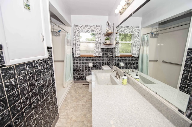 202 E Seminole St, Springfield, MO 65807 - bathroom featuring tile walls, a shower with shower curtain, toilet, a wainscoted wall, and stone finish floors