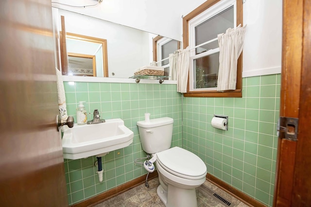 202 E Seminole St, Springfield, MO 65807 - bathroom featuring tile walls, toilet, a sink, and a wainscoted wall