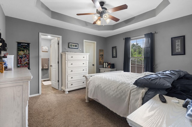1206 S Solaira St, Ozark, MO 65721 - carpeted bedroom featuring a tray ceiling, baseboards, ceiling fan, and ensuite bath