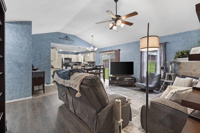 1206 S Solaira St, Ozark, MO 65721 - living room featuring a ceiling fan, vaulted ceiling, wood finished floors, a fireplace, and a chandelier