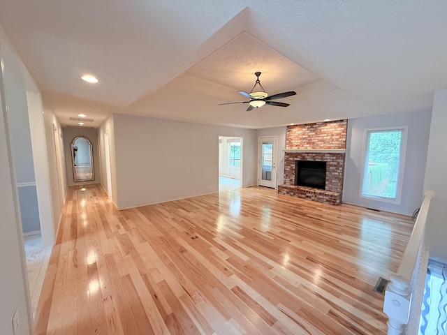 5135 S Clay Ave, Springfield, MO 65810 - unfurnished living room with a tray ceiling, light wood-style floors, a fireplace, ceiling fan, and recessed lighting