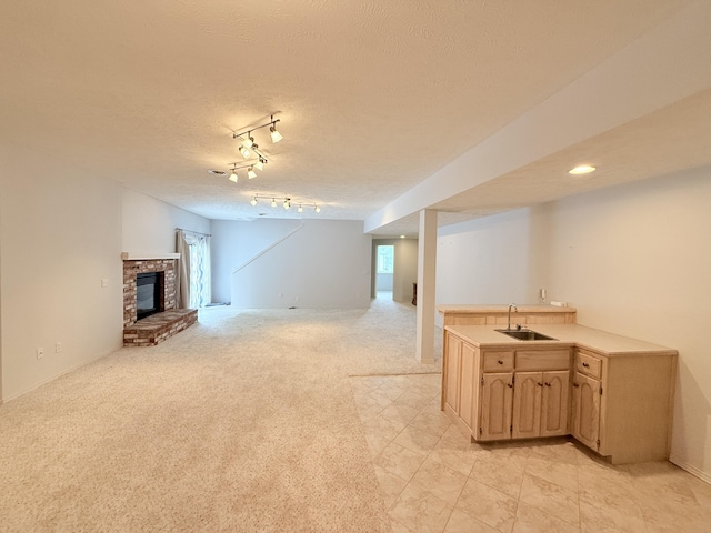 5135 S Clay Ave, Springfield, MO 65810 - unfurnished living room featuring a fireplace, light colored carpet, a textured ceiling, healthy amount of natural light, and rail lighting