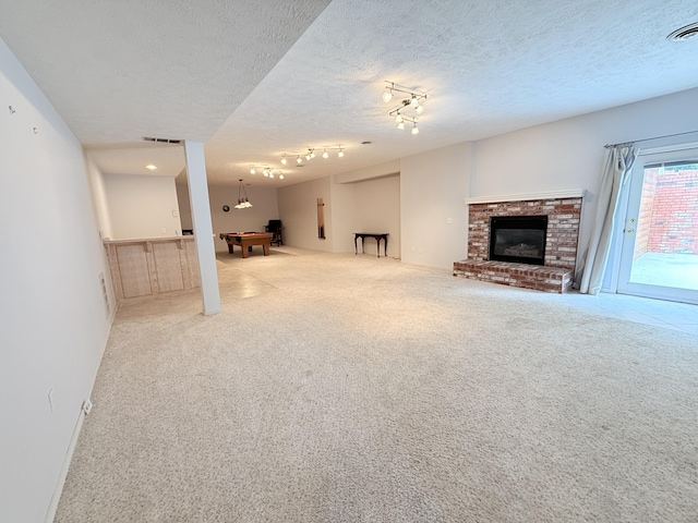 5135 S Clay Ave, Springfield, MO 65810 - unfurnished living room featuring billiards table, carpet flooring, a textured ceiling, and a brick fireplace