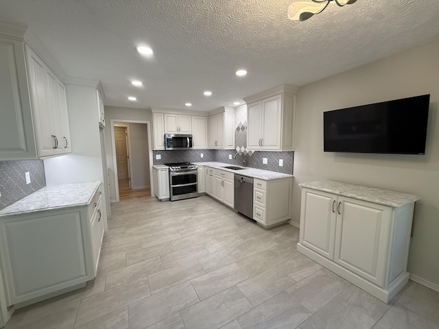 5135 S Clay Ave, Springfield, MO 65810 - kitchen with stainless steel appliances, a sink, decorative backsplash, light countertops, and recessed lighting