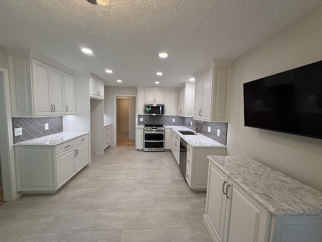 5135 S Clay Ave, Springfield, MO 65810 - kitchen with appliances with stainless steel finishes, a sink, decorative backsplash, recessed lighting, and light stone counters