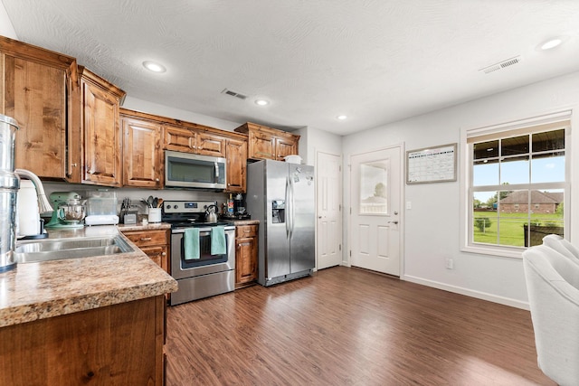1054 Thoroughfare St, Seymour, MO 65746 - kitchen featuring stainless steel appliances, a sink, dark wood-type flooring, brown cabinetry, and light countertops