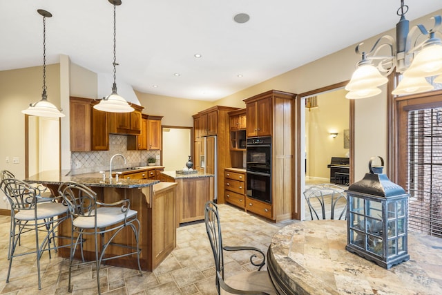 2421 Candlebark Ln, Lebanon, MO 65536 - kitchen with brown cabinets, dark stone countertops, decorative backsplash, a kitchen breakfast bar, and a peninsula