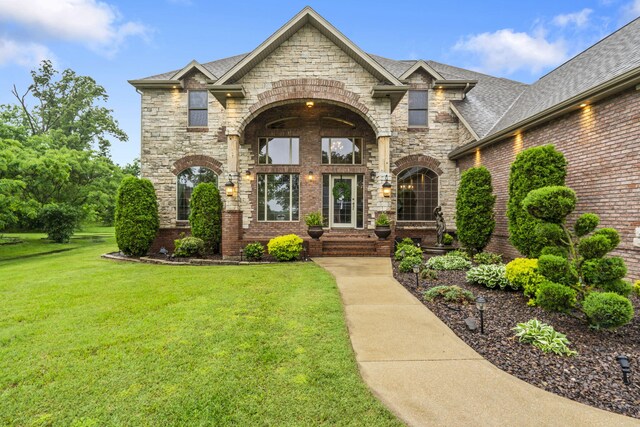 2421 Candlebark Ln, Lebanon, MO 65536 - french country inspired facade featuring a front yard, stone siding, roof with shingles, and brick siding