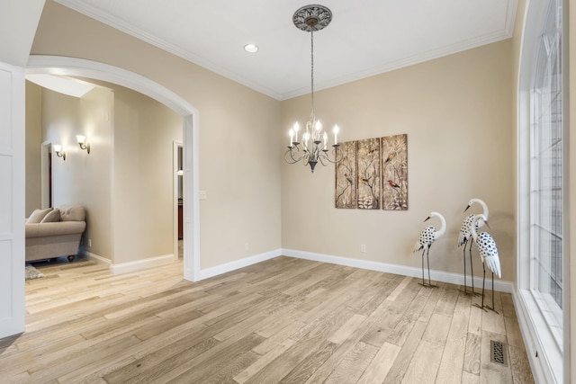 2421 Candlebark Ln, Lebanon, MO 65536 - dining area featuring arched walkways, light wood finished floors, ornamental molding, recessed lighting, and a chandelier