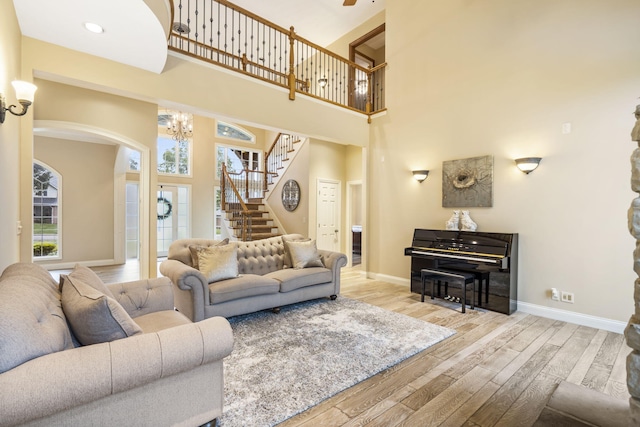 2421 Candlebark Ln, Lebanon, MO 65536 - living room featuring wood finished floors, stairs, arched walkways, a chandelier, and a towering ceiling