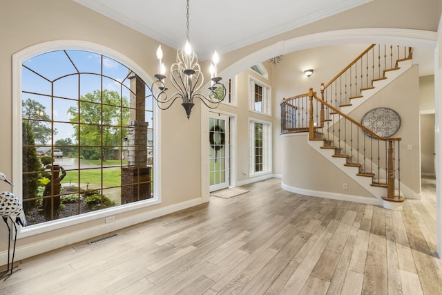 2421 Candlebark Ln, Lebanon, MO 65536 - foyer entrance featuring ornamental molding, light wood finished floors, stairway, a chandelier, and arched walkways