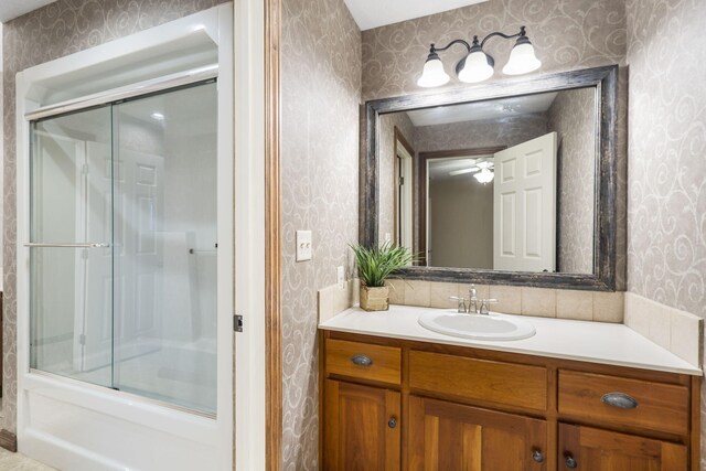 2421 Candlebark Ln, Lebanon, MO 65536 - bathroom featuring wallpapered walls, vanity, shower / bath combination with glass door, and a ceiling fan