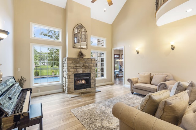 2421 Candlebark Ln, Lebanon, MO 65536 - living room featuring high vaulted ceiling, a ceiling fan, light wood-style flooring, and a stone fireplace