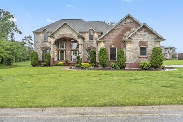 2421 Candlebark Ln, Lebanon, MO 65536 - french country style house with a front lawn, brick siding, a shingled roof, and stone siding