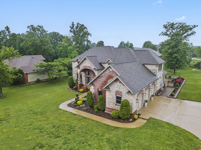 2421 Candlebark Ln, Lebanon, MO 65536 - french country home featuring stone siding, concrete driveway, a front yard, a garage, and roof with shingles