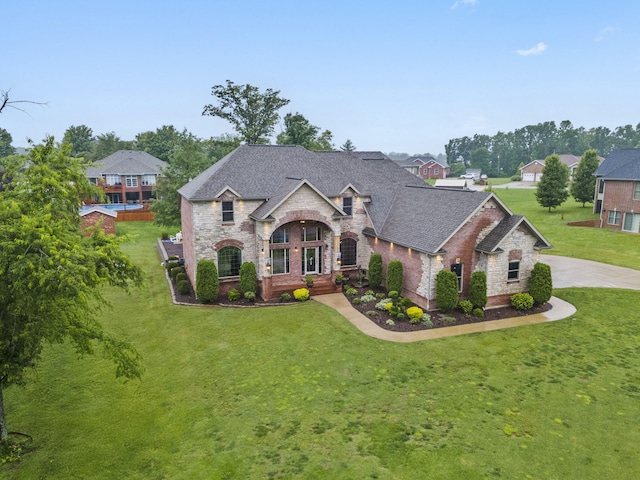 2421 Candlebark Ln, Lebanon, MO 65536 - french country style house with stone siding, roof with shingles, a front yard, brick siding, and a residential view