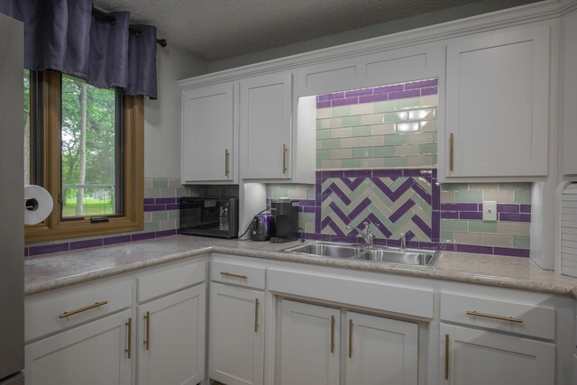 10703 Lawrence Unit 2230, Monett, MO 65708 - kitchen featuring black microwave, a sink, white cabinetry, tasteful backsplash, and light countertops