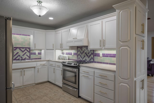 10703 Lawrence Unit 2230, Monett, MO 65708 - kitchen featuring appliances with stainless steel finishes, custom range hood, backsplash, a textured ceiling, and white cabinetry