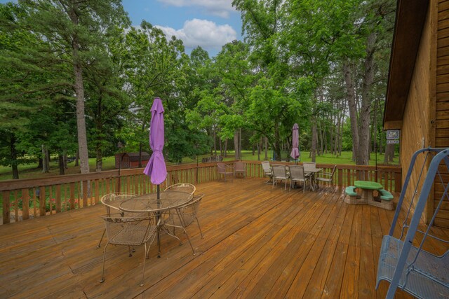 10703 Lawrence Unit 2230, Monett, MO 65708 - wooden deck featuring outdoor dining space and view of wooded area