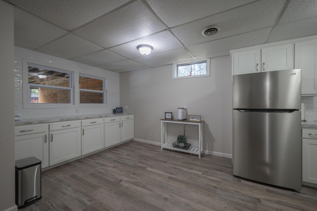 10703 Lawrence Unit 2230, Monett, MO 65708 - kitchen with freestanding refrigerator, a paneled ceiling, white cabinetry, and wood finished floors